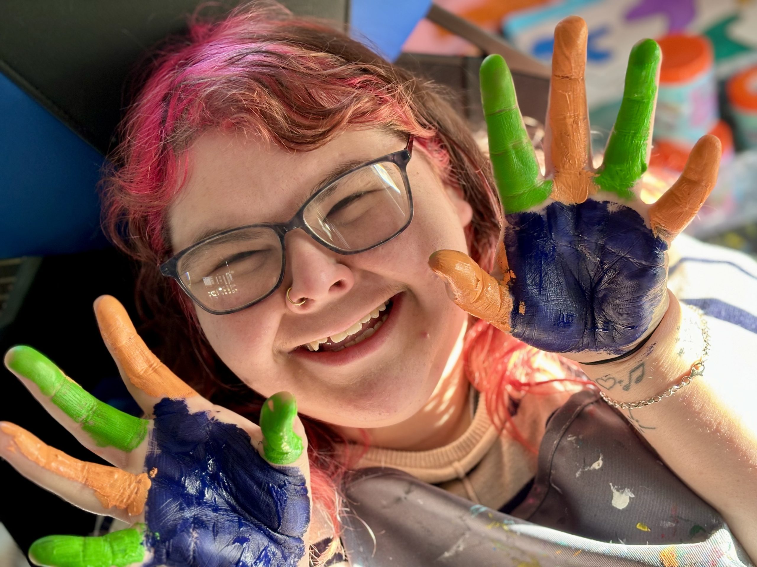 Picture of a Happy TLC Participant Painting with Green, Orange, and Navy Blue